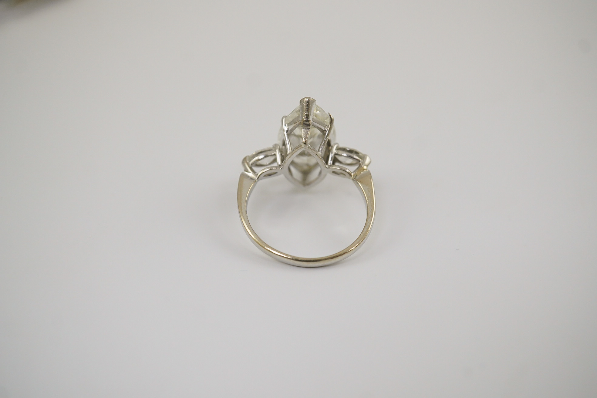 A modern 18ct white gold and single stone marquise cut diamond set ring, with two stone marquise cut diamond set shoulders